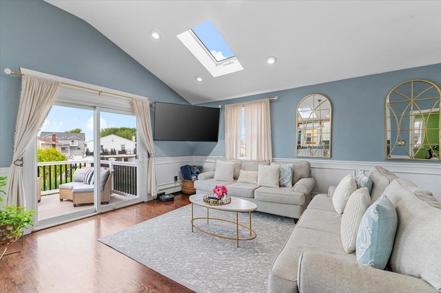 845 Atlantic St, Lindenhurst, NY 11757 - living room featuring a skylight, a baseboard heating unit, a wainscoted wall, lofted ceiling, and wood finished floors