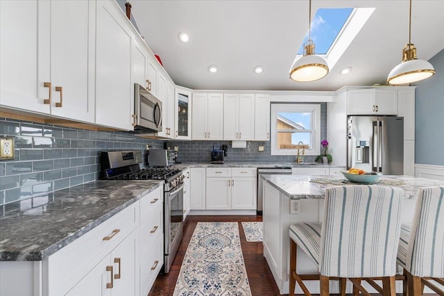 845 Atlantic St, Lindenhurst, NY 11757 - kitchen with stainless steel appliances, a skylight, backsplash, white cabinets, and recessed lighting