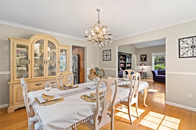 3856 Marcy St, Mohegan Lake, NY 10547 - dining room featuring light wood finished floors, a chandelier, and ornamental molding