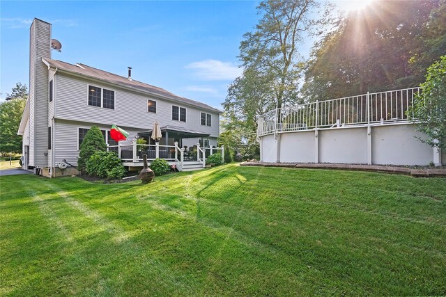 3856 Marcy St, Mohegan Lake, NY 10547 - back of house with a chimney, a deck, and a lawn