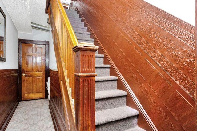 6018 Bleecker St, Ridgewood, NY 11385 - staircase with wainscoting and wooden walls