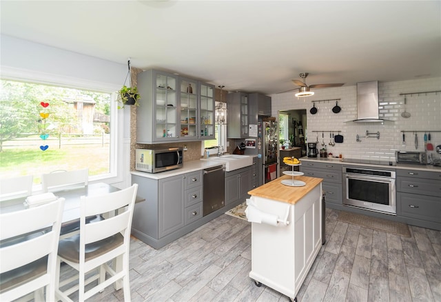2 Sheafe Cir, Rock Tavern, NY 12575 - kitchen featuring gray cabinetry, appliances with stainless steel finishes, wall chimney exhaust hood, and wood counters