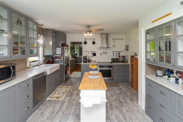 2 Sheafe Cir, Rock Tavern, NY 12575 - kitchen featuring gray cabinetry, appliances with stainless steel finishes, wall chimney exhaust hood, wood counters, and tasteful backsplash
