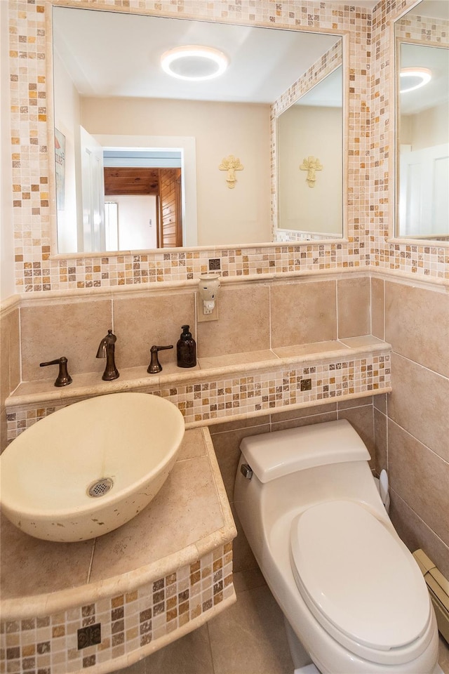 2 Sheafe Cir, Rock Tavern, NY 12575 - half bathroom featuring toilet, decorative backsplash, a sink, a baseboard radiator, and tile walls