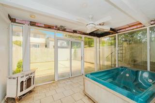 293 Wingham St, Staten Island, NY 10303 - unfurnished sunroom with a jacuzzi, a ceiling fan, and heating unit