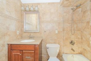 293 Wingham St, Staten Island, NY 10303 - bathroom with vanity, tile walls, toilet, and shower / bath combination