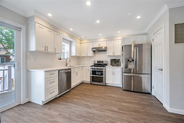 239-53 66th Ave, Little Neck, NY 11362 - kitchen with stainless steel appliances, under cabinet range hood, ornamental molding, a sink, and light countertops