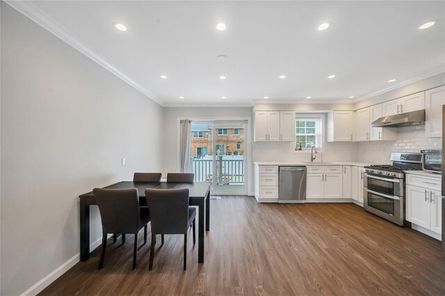 239-53 66th Ave, Little Neck, NY 11362 - kitchen with stainless steel appliances, under cabinet range hood, dark wood finished floors, ornamental molding, and decorative backsplash