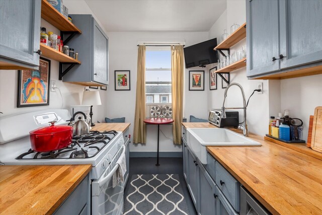 37-75 64th St Unit 51, Woodside, NY 11377 - kitchen featuring butcher block countertops, open shelves, white gas stove, a sink, and gray cabinets