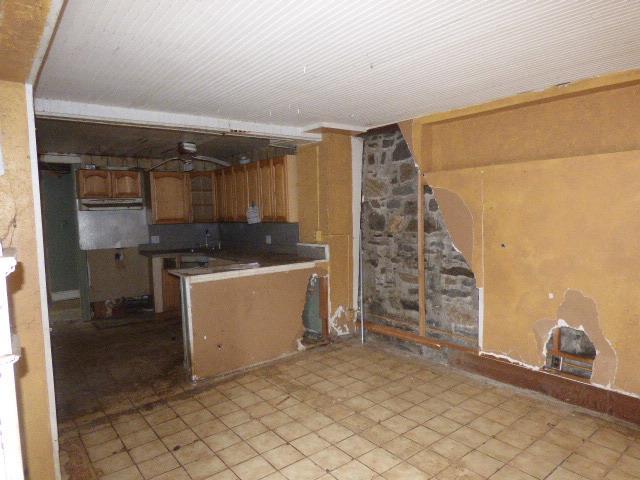 11-10 124th St, College Point, NY 11356 - kitchen with brown cabinets, dark countertops, and a peninsula