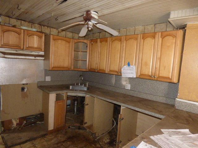 11-10 124th St, College Point, NY 11356 - kitchen featuring a sink, a ceiling fan, and glass insert cabinets