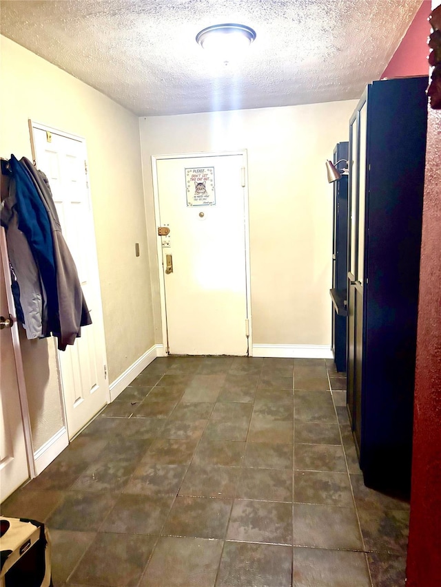 61 Bronx River Rd Unit 8E, Yonkers, NY 10704 - entrance foyer with a textured ceiling, dark tile patterned floors, and baseboards