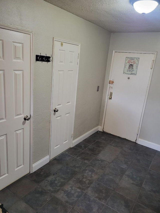 61 Bronx River Rd Unit 8E, Yonkers, NY 10704 - foyer with baseboards and a textured ceiling