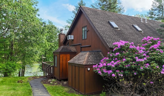 24 Lakeview Ter, Monticello, NY 12701 - view of property exterior with roof with shingles, a chimney, and a wall unit AC