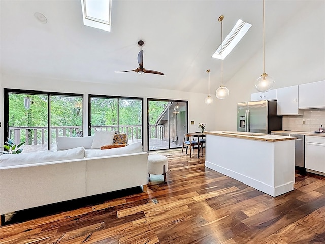 24 Lakeview Ter, Monticello, NY 12701 - kitchen with a skylight, stainless steel fridge with ice dispenser, white cabinetry, open floor plan, and dark wood-style floors