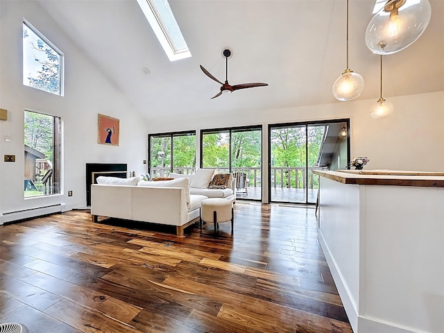 24 Lakeview Ter, Monticello, NY 12701 - living area with high vaulted ceiling, dark wood-style flooring, a baseboard radiator, a skylight, and healthy amount of natural light