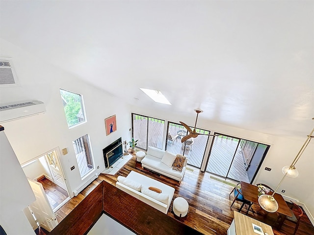 24 Lakeview Ter, Monticello, NY 12701 - living area featuring wood finished floors, a skylight, a glass covered fireplace, and a wall mounted AC