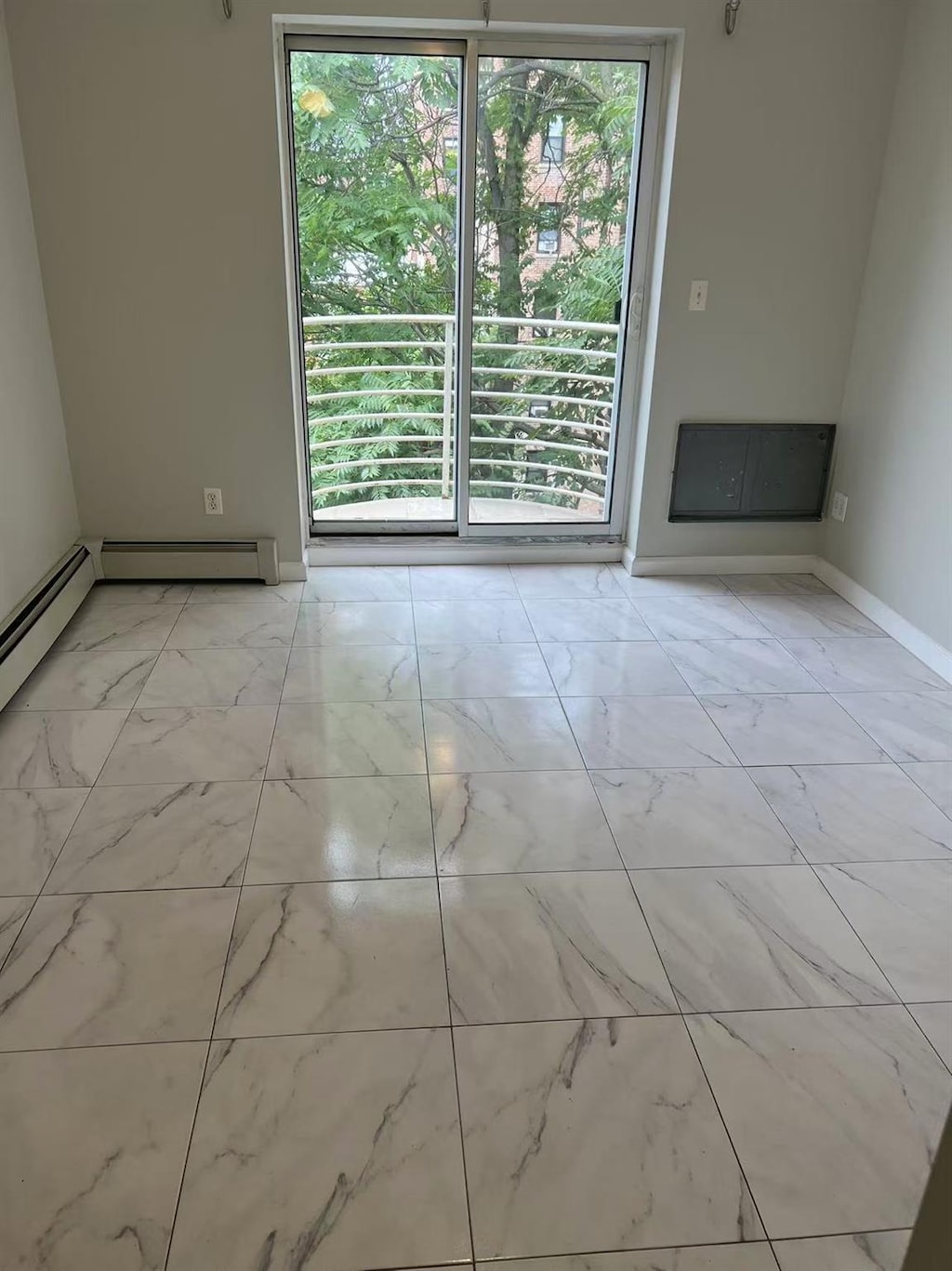 132-73 Maple Ave Unit 4D, Flushing, NY 11355 - spare room with light marble finish flooring, baseboards, and a baseboard radiator