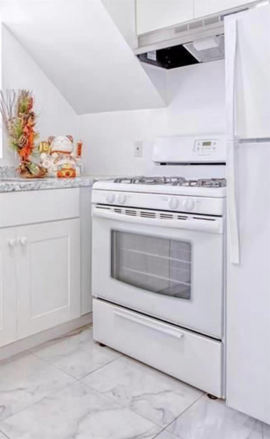 132-73 Maple Ave Unit 4D, Flushing, NY 11355 - kitchen with white appliances, light marble finish flooring, and light countertops