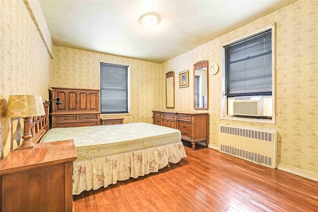 25-11 Union St Unit 2G, Flushing, NY 11354 - bedroom with radiator, wallpapered walls, wood finished floors, and cooling unit