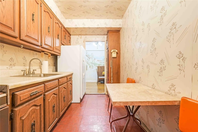 25-11 Union St Unit 2G, Flushing, NY 11354 - kitchen featuring wallpapered walls, a sink, freestanding refrigerator, light countertops, and brown cabinets