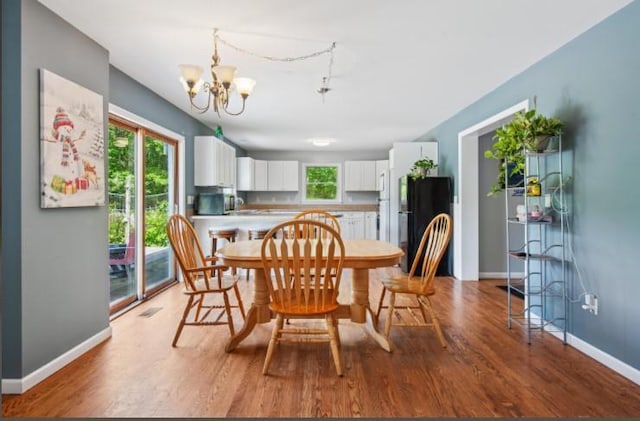 484 N Magee St, Southampton, NY 11968 - dining space featuring a chandelier, wood finished floors, and baseboards