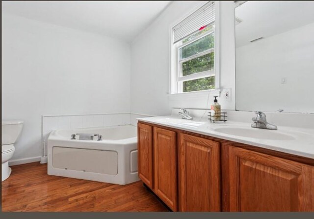 484 N Magee St, Southampton, NY 11968 - full bathroom with toilet, a bath, double vanity, and wood finished floors