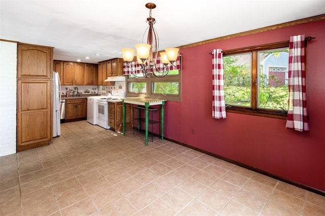 94 E Way, Mount Kisco, NY 10549 - kitchen with white appliances, a chandelier, brown cabinetry, under cabinet range hood, and light countertops