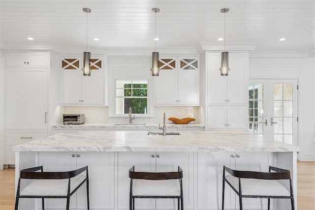 41 Landing Ln, East Quogue, NY 11942 - kitchen with a sink, white cabinetry, a kitchen breakfast bar, and recessed lighting
