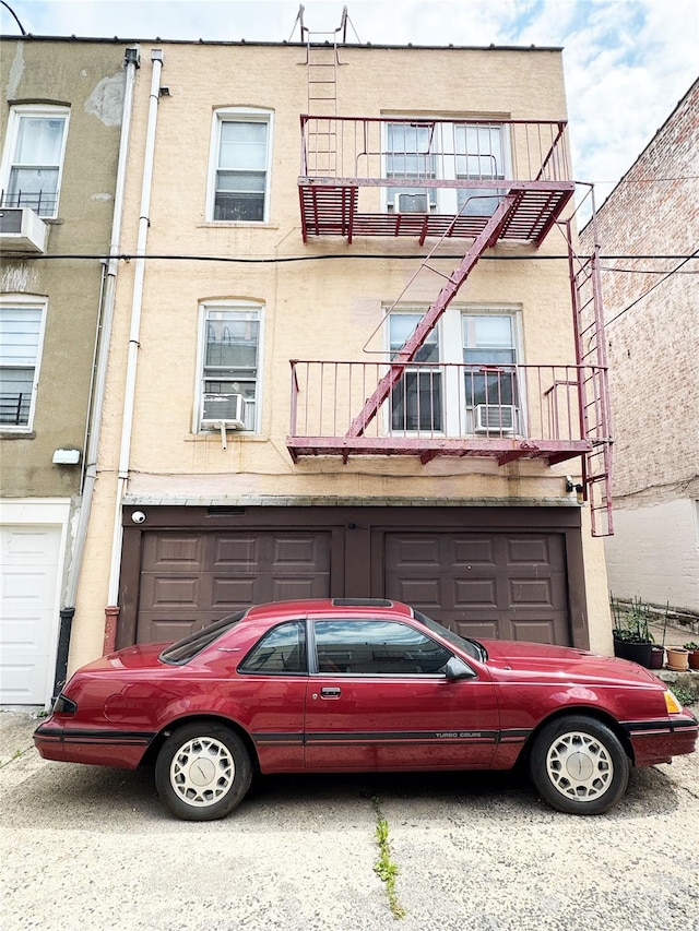 1840 21st Dr, Astoria, NY 11105 - view of front of property with an attached garage, cooling unit, and stucco siding