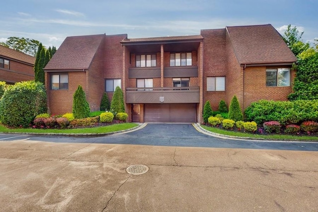 14 Acorn Ponds Dr Unit 14, Roslyn, NY 11576 - view of front of house with brick siding, a balcony, asphalt driveway, and a garage