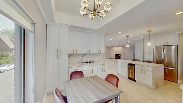 14 Acorn Ponds Dr Unit 14, Roslyn, NY 11576 - kitchen featuring freestanding refrigerator, wine cooler, decorative backsplash, white cabinetry, and a chandelier