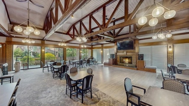 14 Acorn Ponds Dr Unit 14, Roslyn, NY 11576 - dining area with high vaulted ceiling, beam ceiling, and a warm lit fireplace