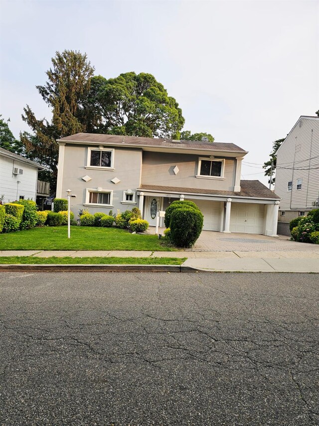 511 Chesman St, Hempstead, NY 11552 - traditional-style home featuring driveway, a front lawn, and a garage