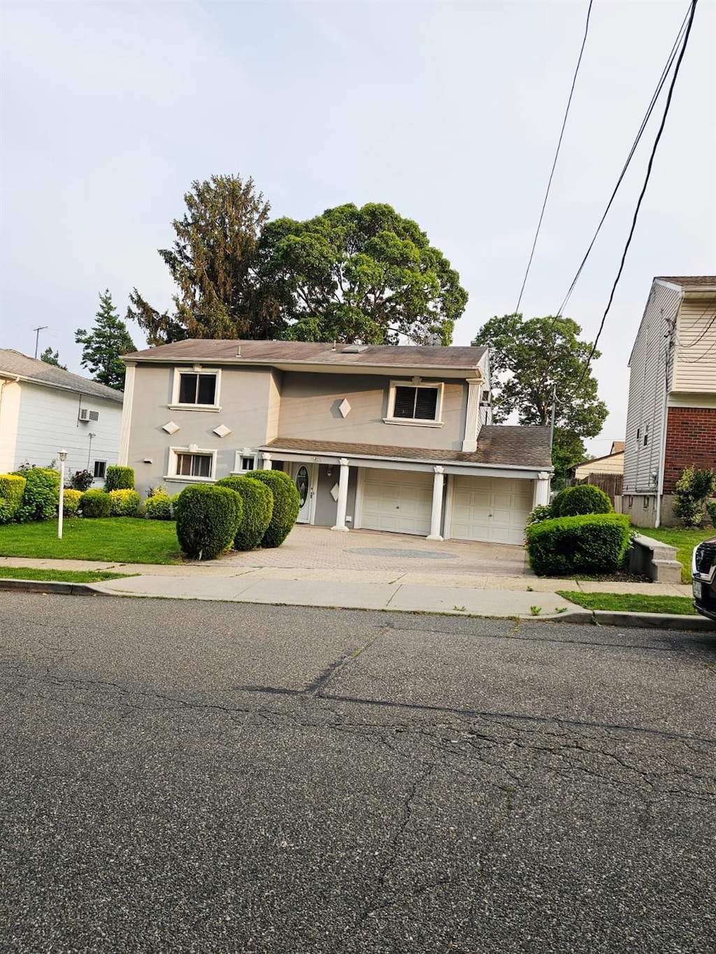 511 Chesman St, Hempstead, NY 11552 - traditional-style home featuring driveway and an attached garage