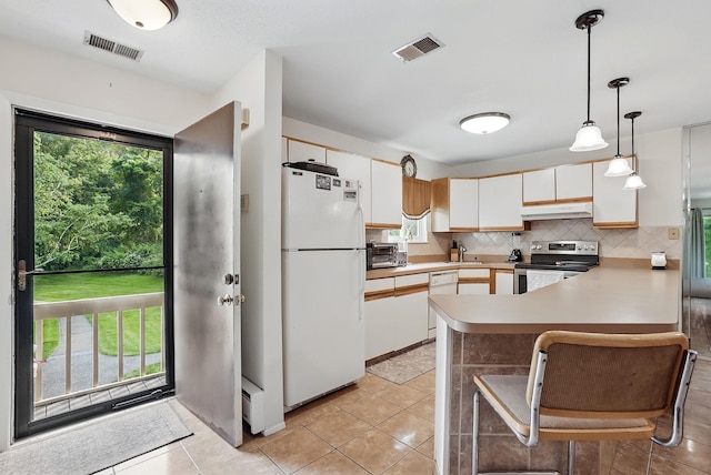 34 Overlook Commons, Yorktown Heights, NY 10598 - kitchen featuring white appliances, under cabinet range hood, a peninsula, and healthy amount of natural light