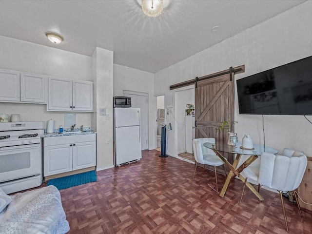 550 W 153rd St Unit 41, New York Manhattan, NY 10031 - kitchen with white appliances, a barn door, light countertops, white cabinets, and a sink