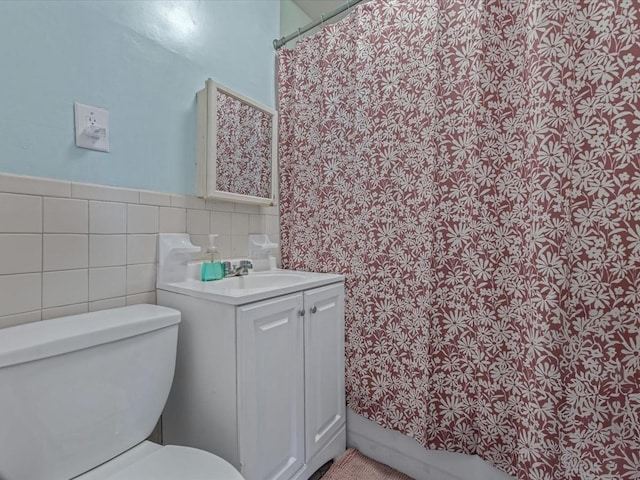 550 W 153rd St Unit 41, New York Manhattan, NY 10031 - bathroom featuring vanity, toilet, curtained shower, wainscoting, and tile walls
