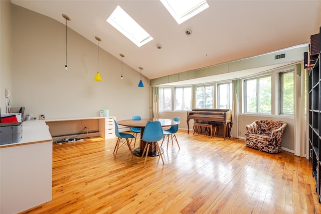 3929 Greentree Dr, Oceanside, NY 11572 - dining area with light wood finished floors, a skylight, and high vaulted ceiling