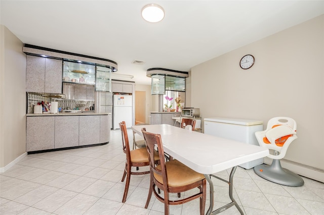 3929 Greentree Dr, Oceanside, NY 11572 - dining room with light tile patterned floors, baseboard heating, and baseboards