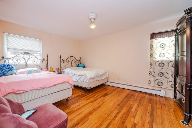 3929 Greentree Dr, Oceanside, NY 11572 - bedroom featuring baseboard heating and light wood finished floors
