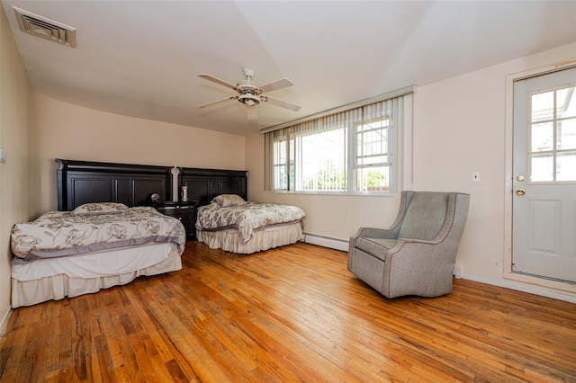 3929 Greentree Dr, Oceanside, NY 11572 - bedroom featuring baseboard heating, light wood-style floors, and a ceiling fan