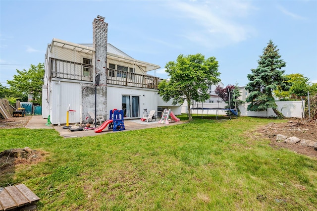 3929 Greentree Dr, Oceanside, NY 11572 - rear view of property featuring a balcony, a patio, a chimney, and a trampoline