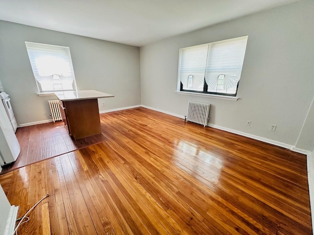 216-04 47th Ave Unit 1A, Bayside, NY 11361 - spare room with radiator, wood-type flooring, and baseboards