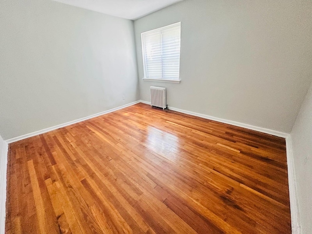 216-04 47th Ave Unit 1A, Bayside, NY 11361 - unfurnished room featuring radiator heating unit, light wood-style flooring, and baseboards