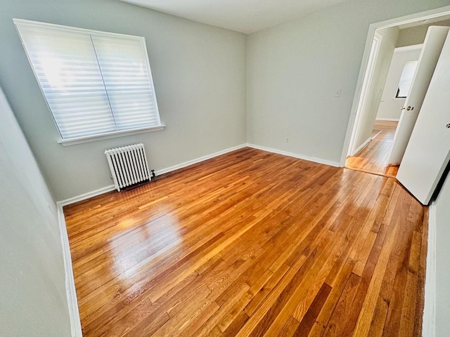 216-04 47th Ave Unit 1A, Bayside, NY 11361 - unfurnished room featuring radiator heating unit, wood finished floors, and baseboards