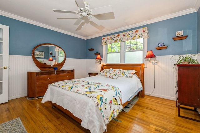 96 N Howells Point Rd, Bellport Village, NY 11713 - bedroom with wainscoting, hardwood / wood-style floors, crown molding, and ceiling fan
