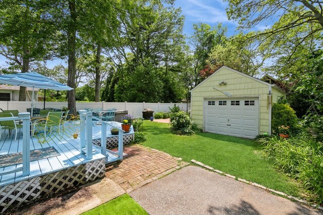 96 N Howells Point Rd, Bellport Village, NY 11713 - view of yard with outdoor dining area, a garage, a wooden deck, an outbuilding, and driveway