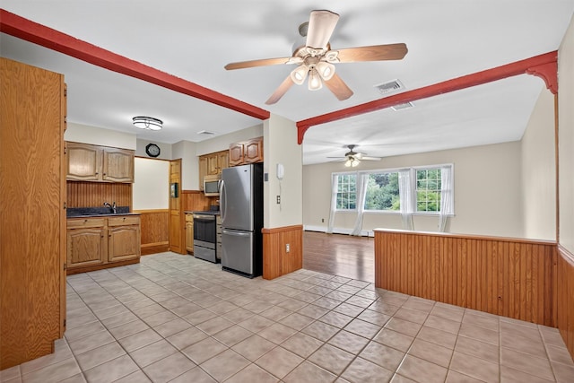 69 Crafts Rd, Carmel, NY 10512 - kitchen featuring stainless steel appliances, a wainscoted wall, ceiling fan, light tile patterned floors, and brown cabinets