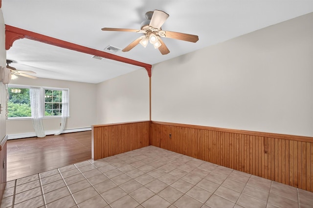 69 Crafts Rd, Carmel, NY 10512 - unfurnished room with ceiling fan, baseboard heating, a wainscoted wall, wooden walls, and light tile patterned floors